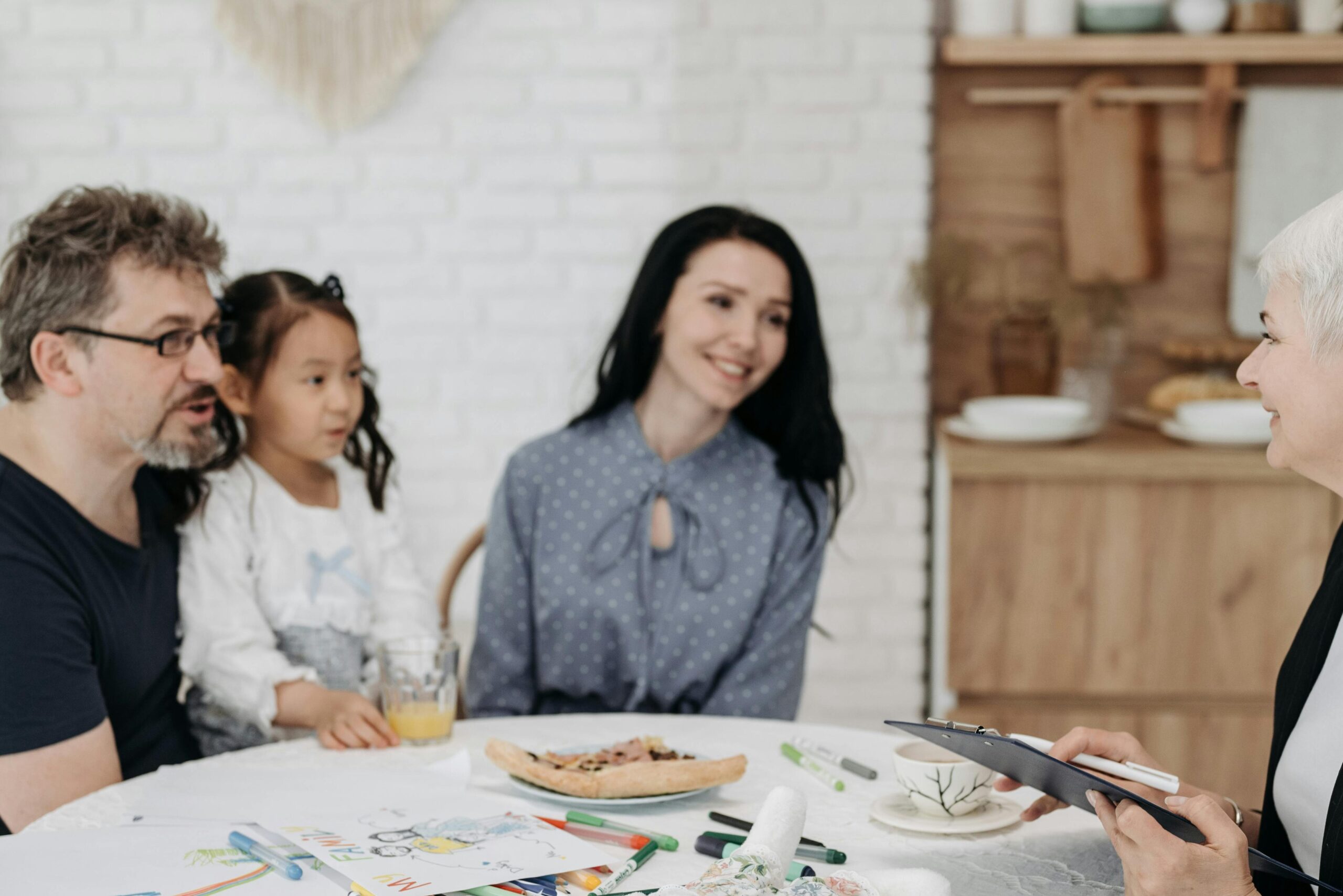 Adoptive family discussing with a social worker indoors, creating a warm, welcoming atmosphere.
